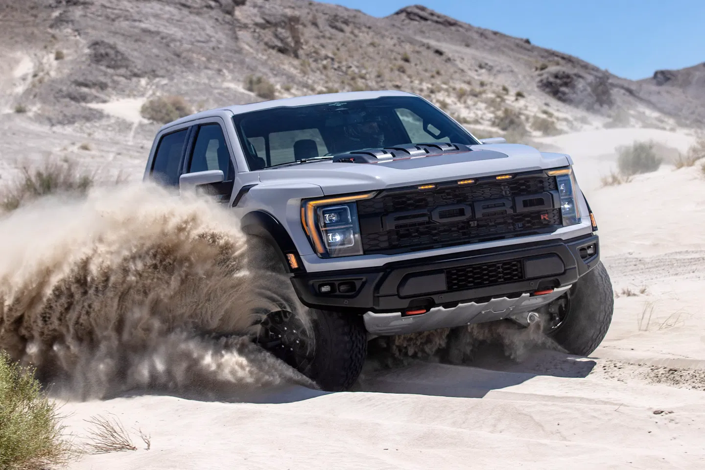 Off-road performance truck driving through sand